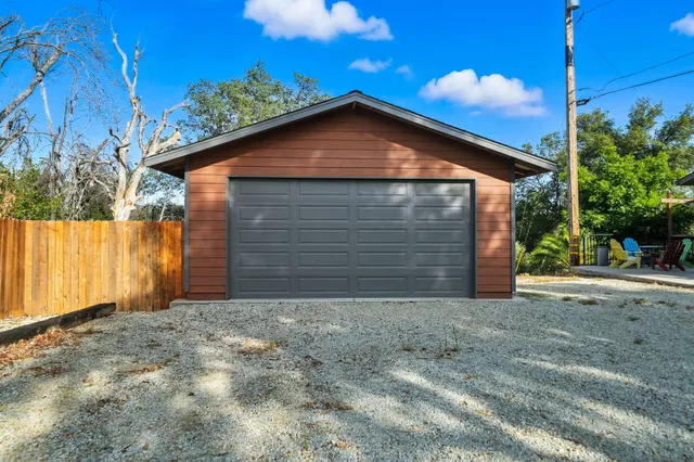 an aerial view of residential houses with outdoor space and trees