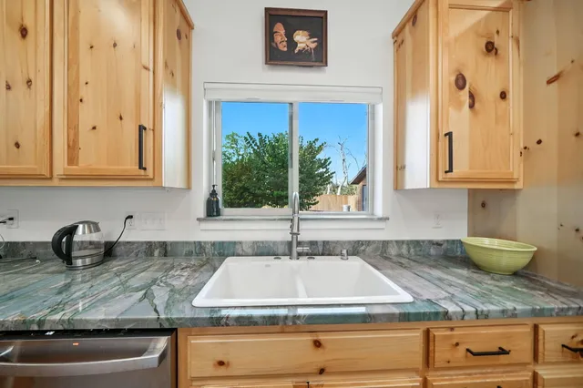 a kitchen with stainless steel appliances granite countertop a sink and a stove