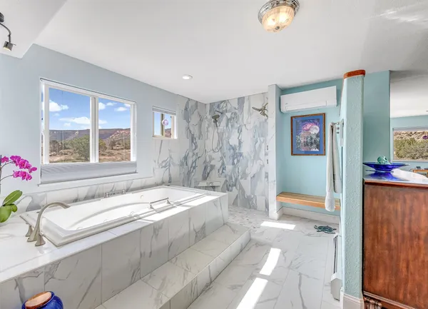 a spacious bathroom with a tub sink and mirror