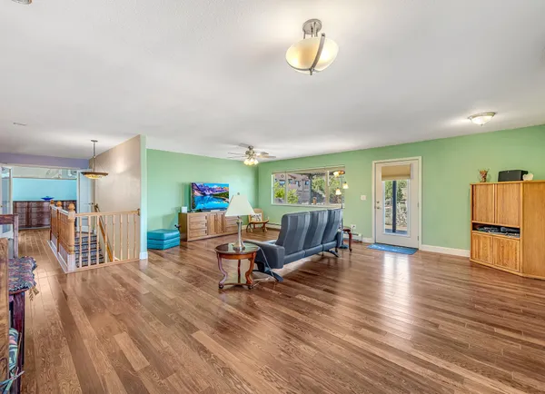 a living room with furniture and a wooden floor