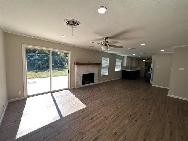 a view of an empty room with a fireplace and a window