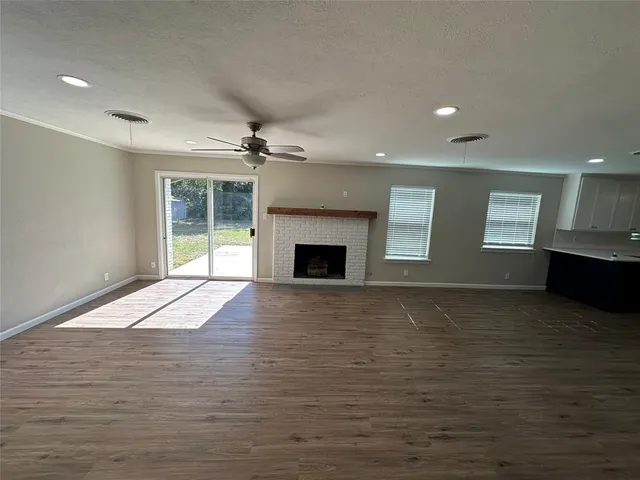 a view of an empty room with a fireplace and a window