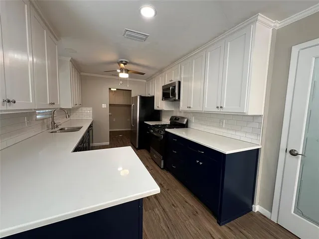 a kitchen with a sink refrigerator and cabinets