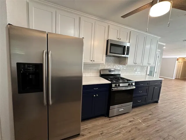 a kitchen with stainless steel appliances granite countertop a refrigerator and a stove