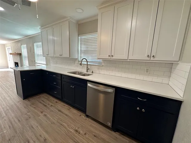 a kitchen with stainless steel appliances granite countertop a sink dishwasher a stove a refrigerator and cabinets with wooden floor