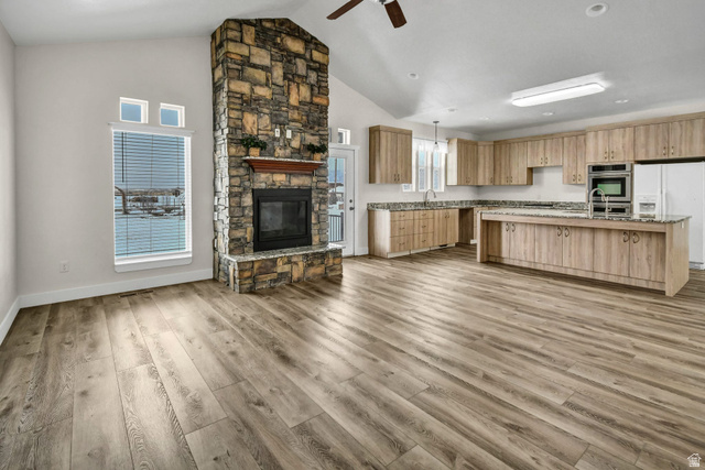 1103 North Brooklyn Road Monroe, UT 84754 - Photo 78 of 78 Kitchen featuring open floor plan, white fridge with ice dispenser, a fireplace, ceiling fan, and a kitchen island with sink