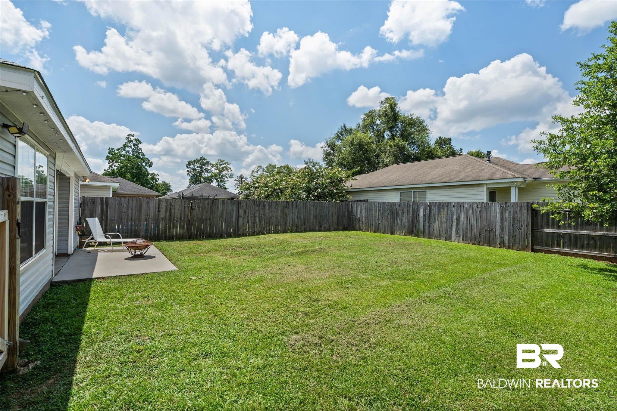 8980 Spring Grove North Mobile, AL 36695 - Photo 20 of 24 Expansive backyard featuring a large green lawn, concrete patio, and full privacy fencing