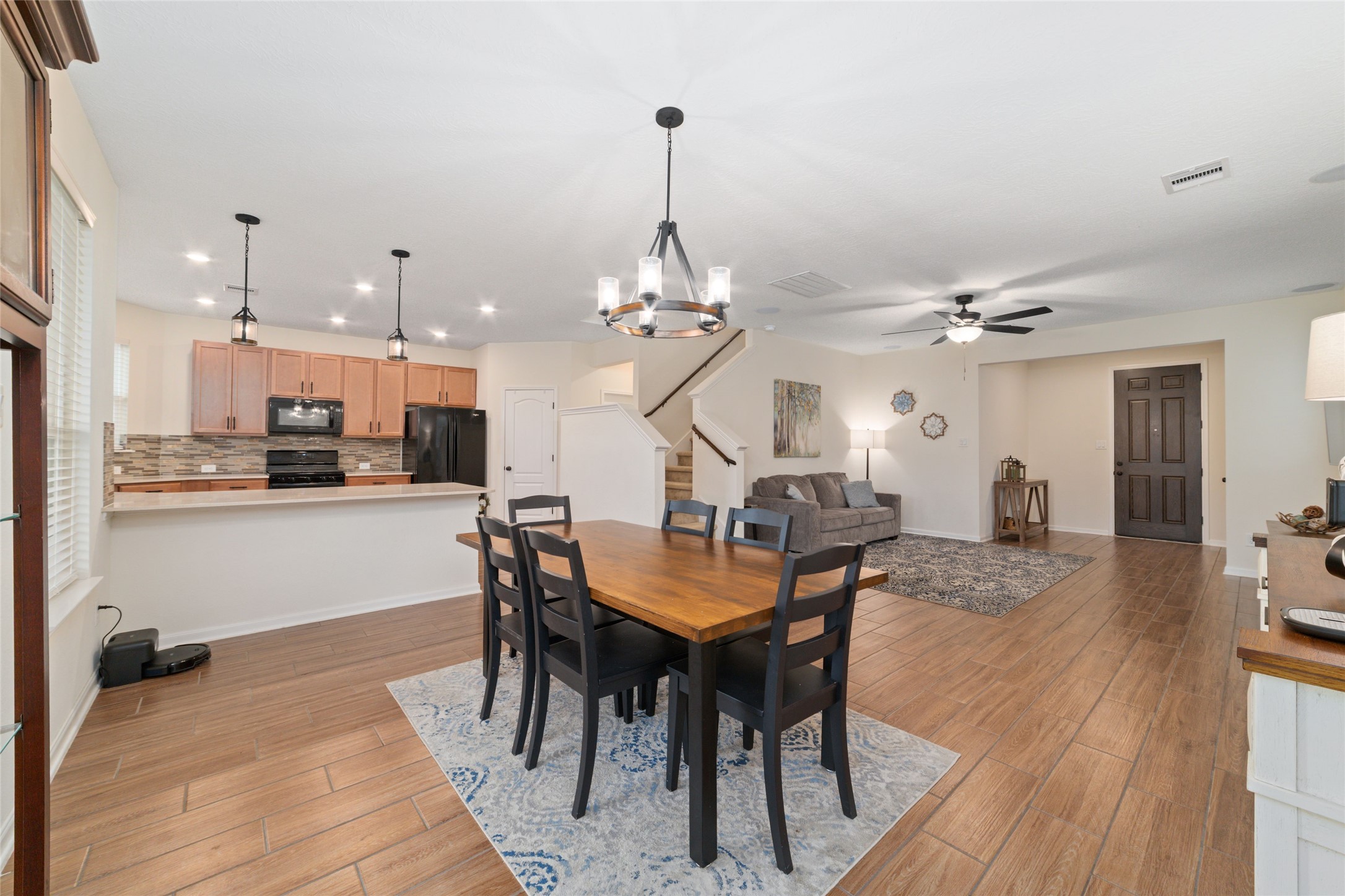 25414 Whitehaven Gate Street Katy, TX 77493 - Photo 11 of 32 a view of a dining room and livingroom with furniture wooden floor a chandelier