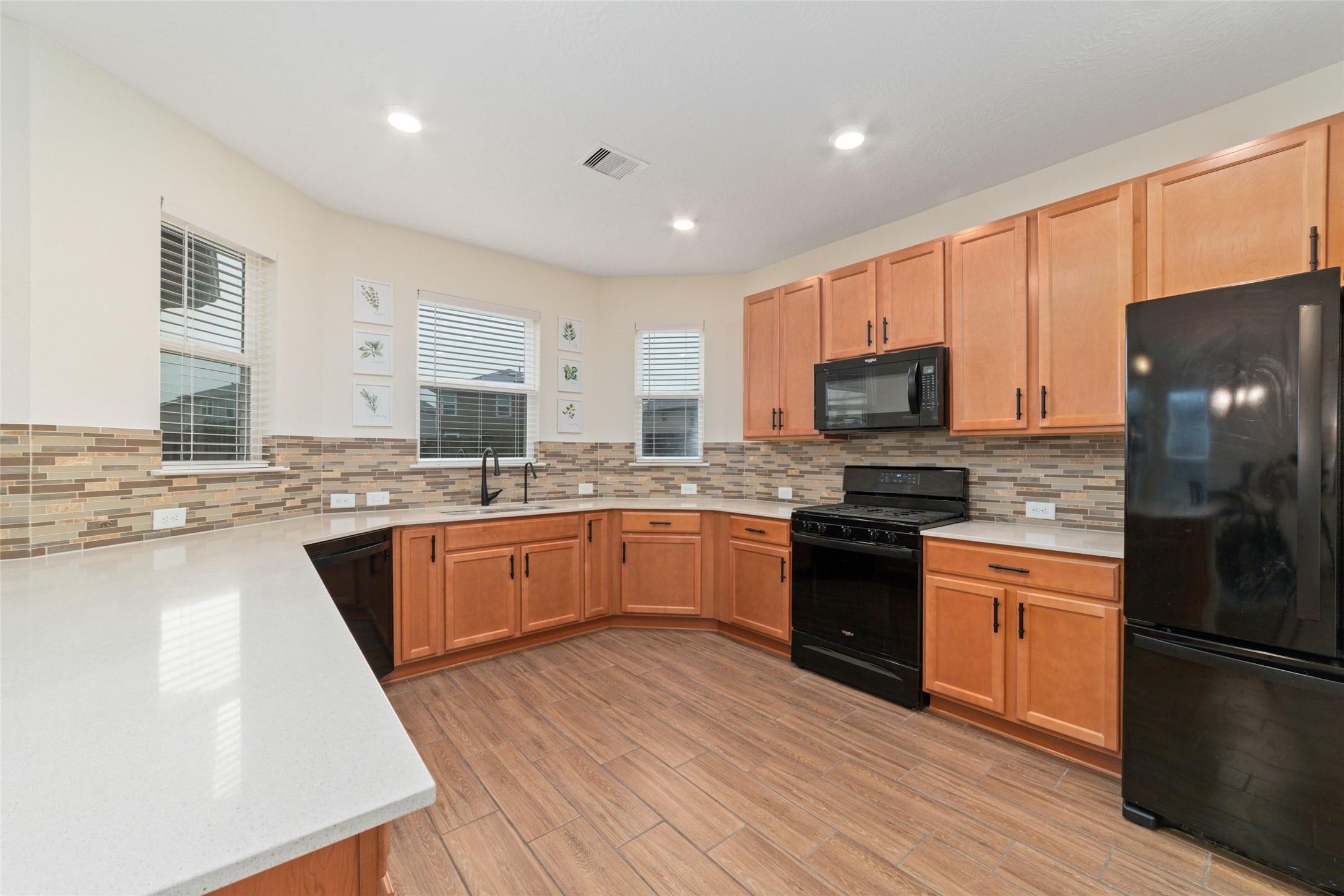 25414 Whitehaven Gate Street Katy, TX 77493 - Photo 13 of 32 a kitchen with stainless steel appliances granite countertop a refrigerator a stove top oven a sink dishwasher and wooden cabinets with wooden floor