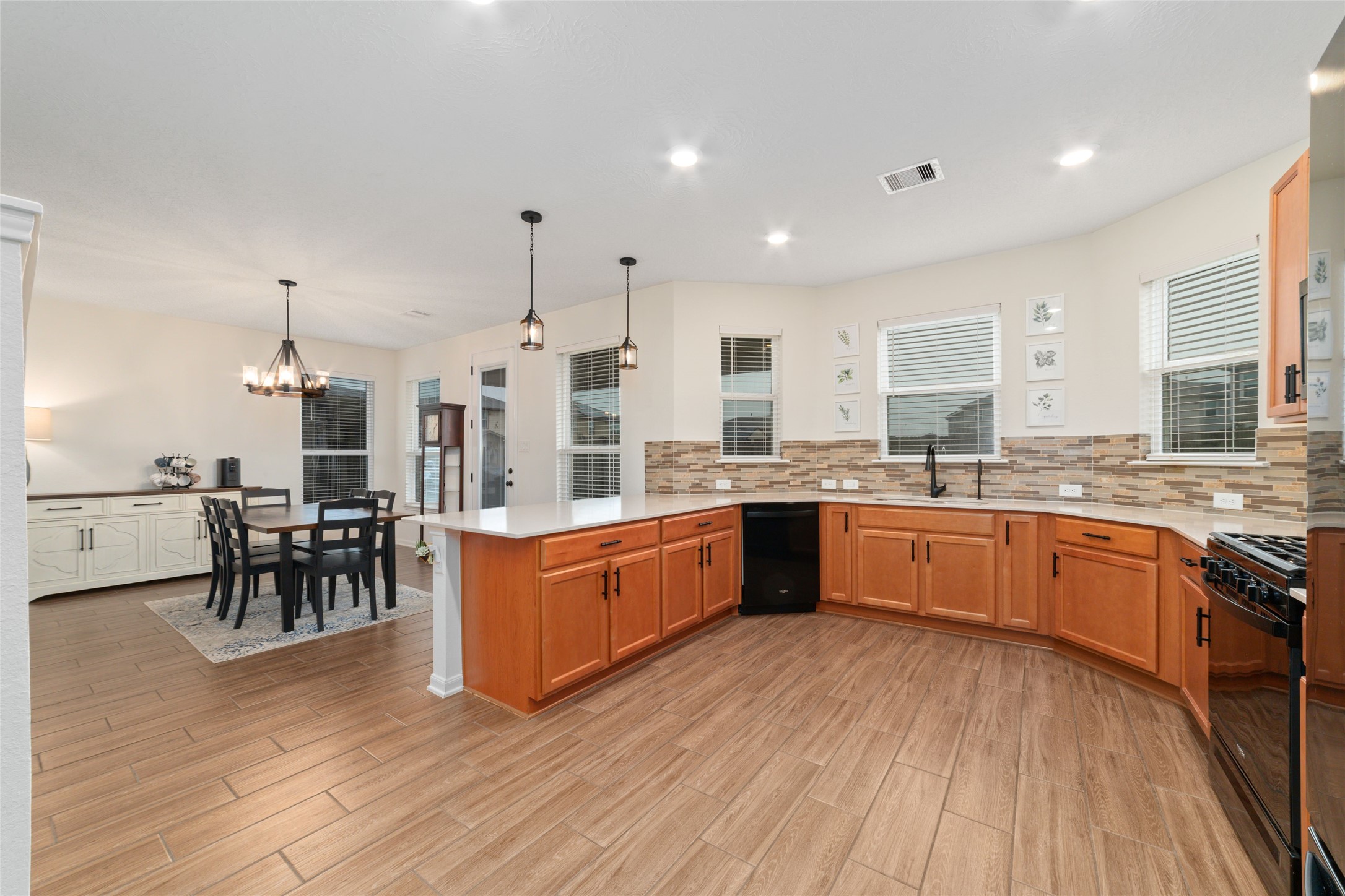 25414 Whitehaven Gate Street Katy, TX 77493 - Photo 14 of 32 a large kitchen with stainless steel appliances wooden floors and wooden cabinets