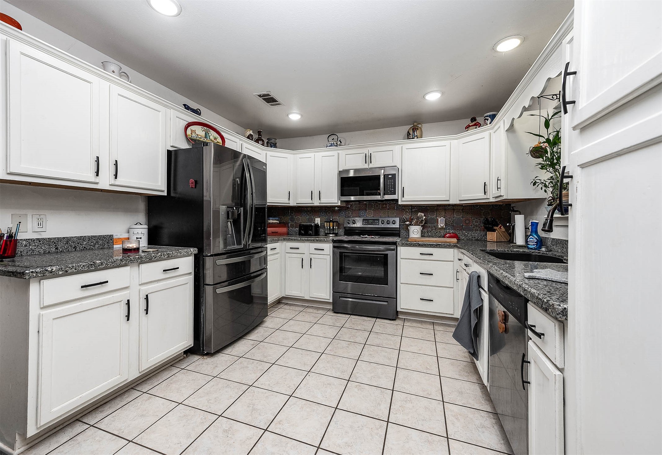 100 Magnolia Place Coldspring, TX 77331 - Photo 12 of 50 a kitchen with stainless steel appliances granite countertop a refrigerator and a stove top oven