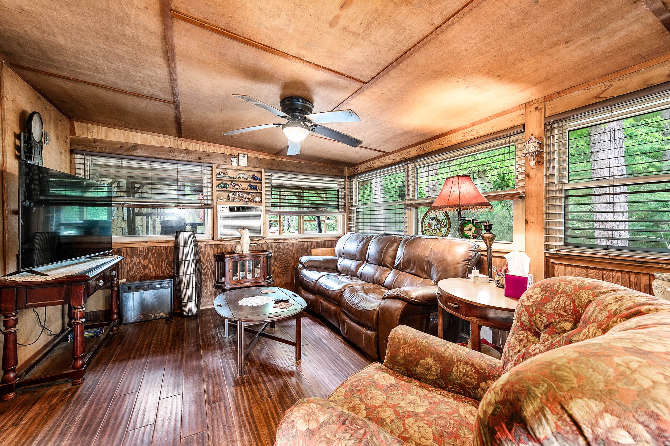 100 Magnolia Place Coldspring, TX 77331 - Photo 16 of 50 a living room with furniture a flat screen tv and a floor to ceiling window
