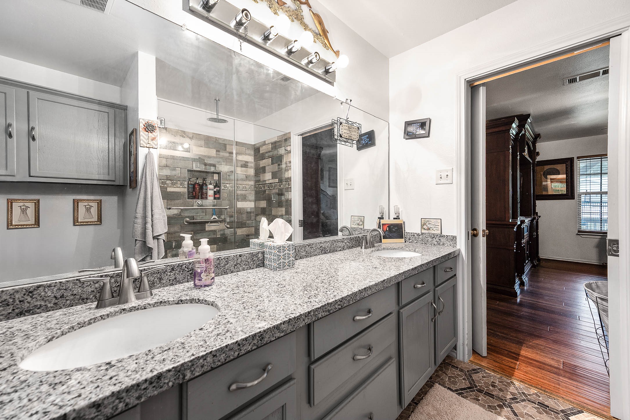 100 Magnolia Place Coldspring, TX 77331 - Photo 26 of 50 a bathroom with a granite countertop double vanity sink and a mirror