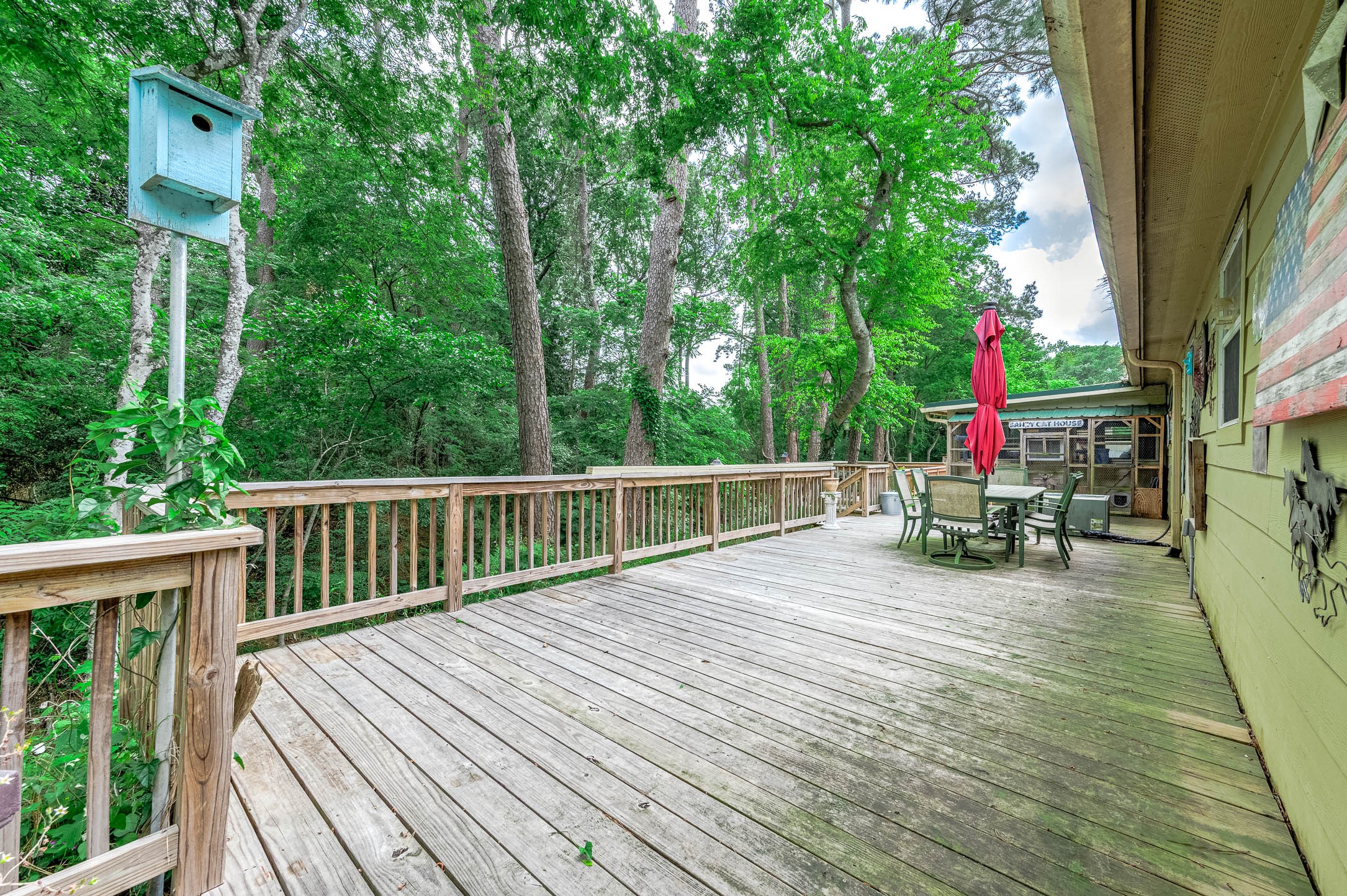 100 Magnolia Place Coldspring, TX 77331 - Photo 41 of 50 a view of house with deck outdoor seating and green space