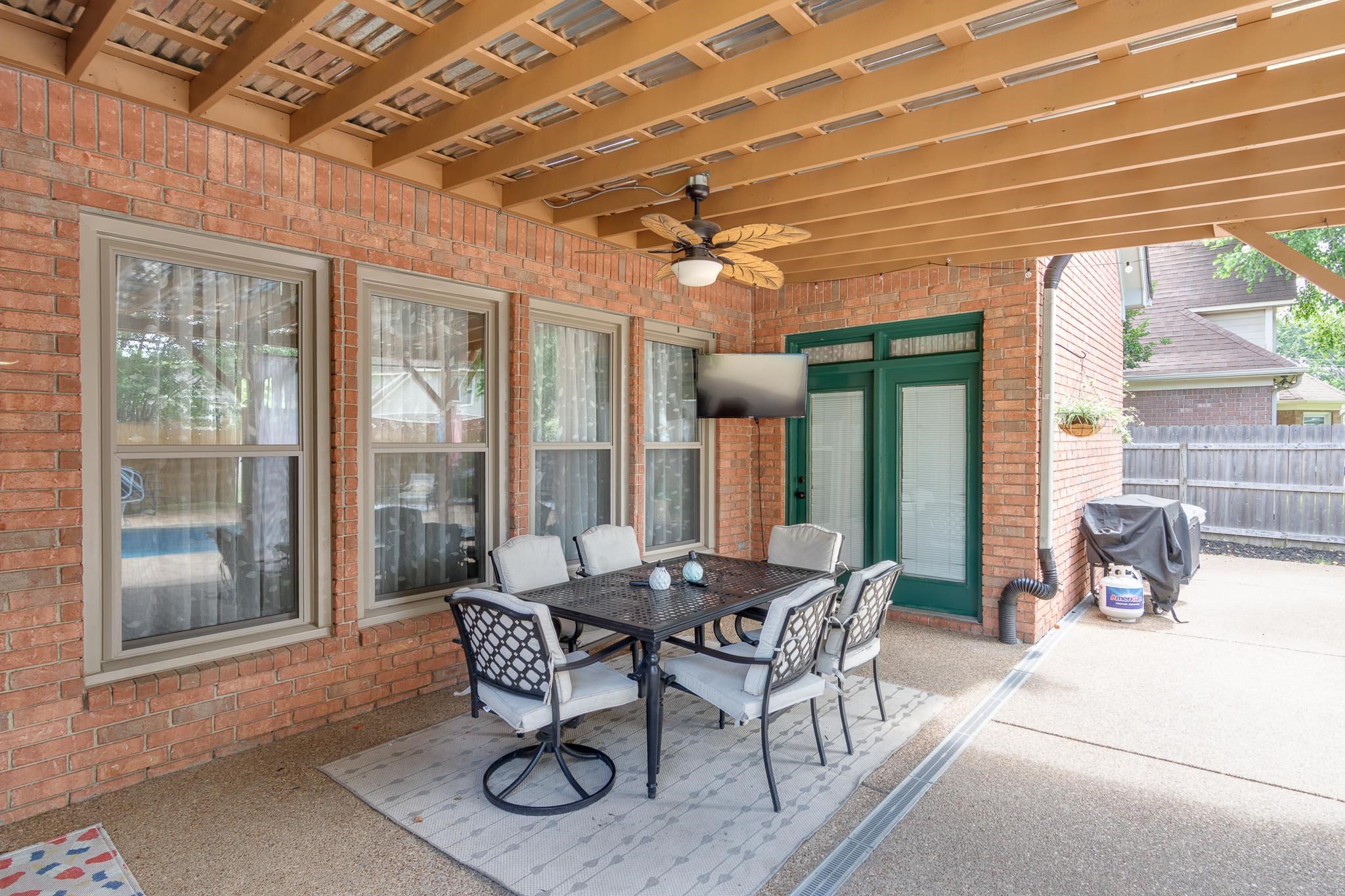 779 Early Earner Cove Collierville, TN 38017 - Photo 22 of 29 Covered patio featuring a wood-beam ceiling, exposed brick exterior, and a ceiling fan