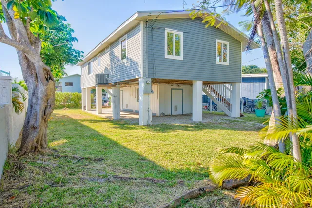a view of a livingroom with furniture wooden floor ceiling fan and windows
