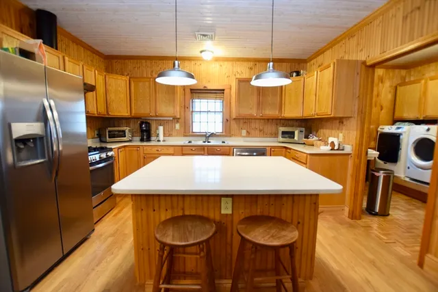 a kitchen with stainless steel appliances granite countertop a sink a stove and a refrigerator