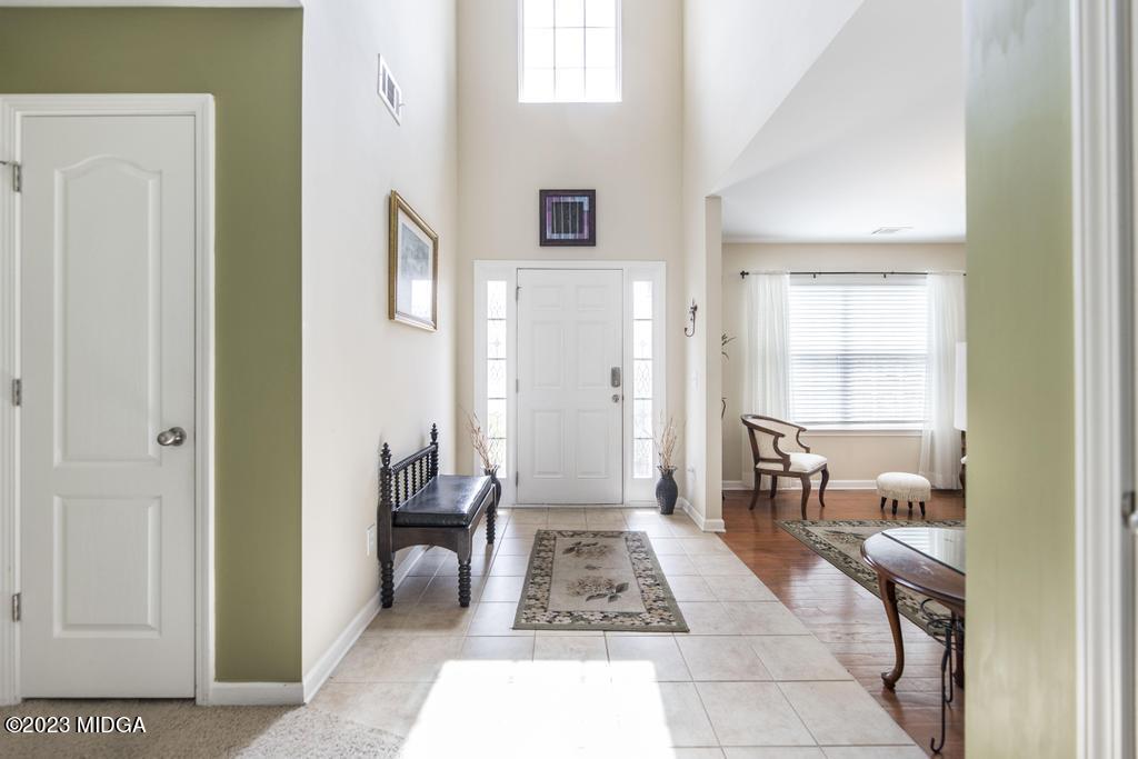 901 Broderick Circle Warner Robins, GA 31088 - Photo 2 of 19 a hallway with a couch and a dining table next to a window