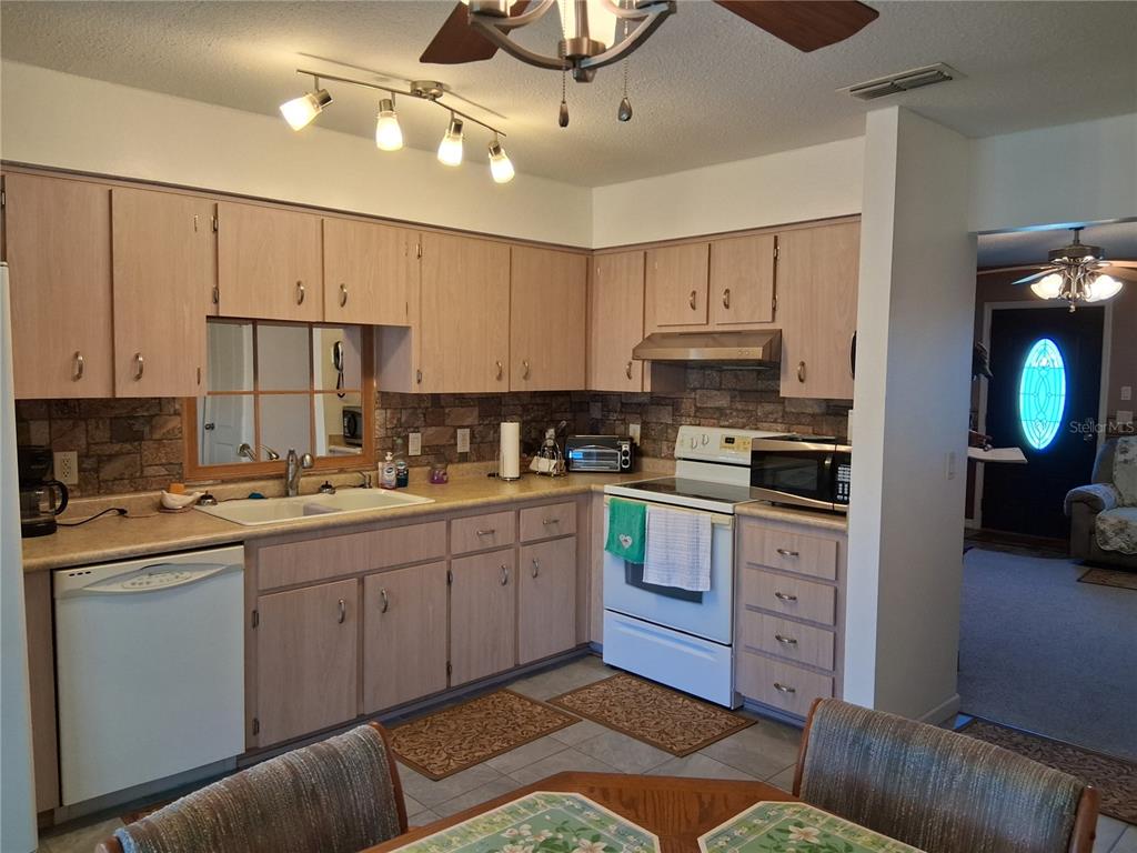 515 Boitnott Lane Bushnell, FL 33513 - Photo 11 of 13 a kitchen with kitchen island granite countertop a sink cabinets and stainless steel appliances