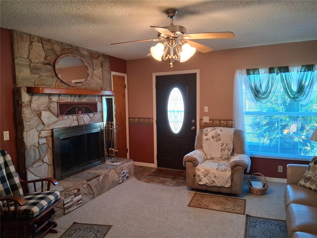 515 Boitnott Lane Bushnell, FL 33513 - Photo 7 of 13 a living room with furniture a chandelier and a fireplace
