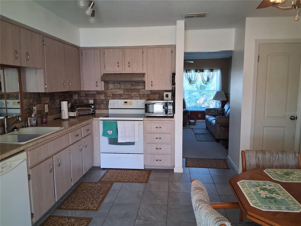515 Boitnott Lane Bushnell, FL 33513 - Photo 9 of 13 a kitchen with cabinets appliances and a window