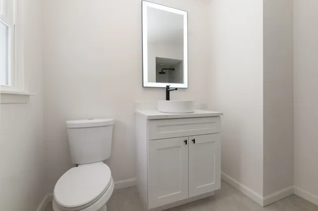 a bathroom with a toilet sink and mirror