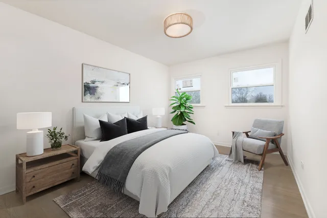 a bedroom with bed and a painting on the wall