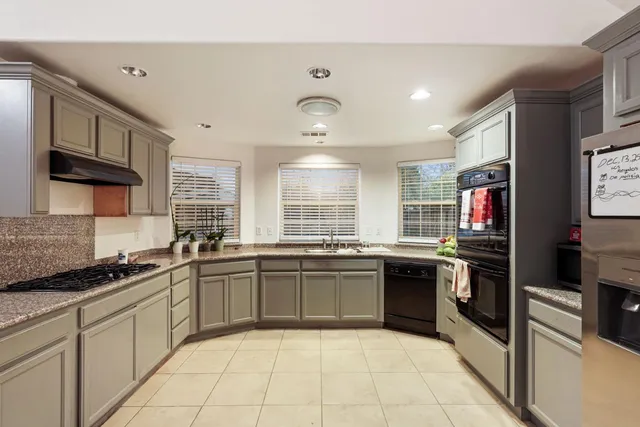 a large kitchen with stainless steel appliances granite countertop a stove and a sink