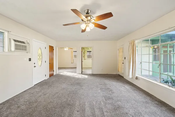 an empty room with fan and windows