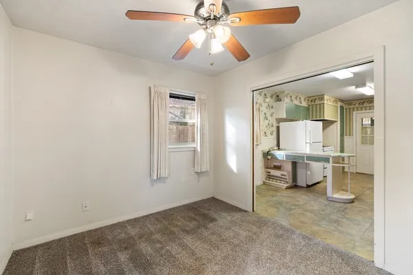 a view of a room with a flat screen tv and chandelier fan