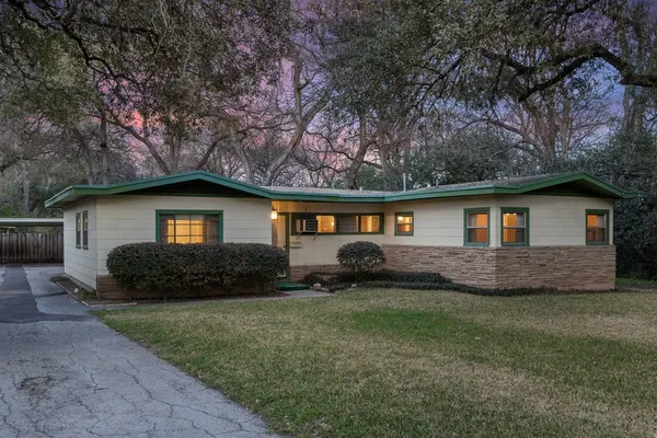 a front view of a house with a yard and trees