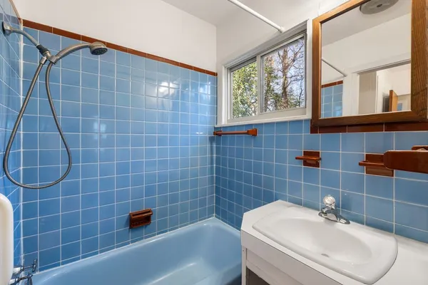 a bathroom with a sink a window and tub