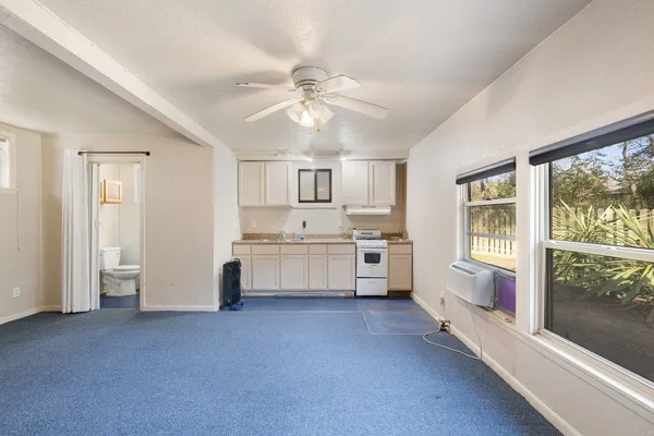 a kitchen with white cabinets and window