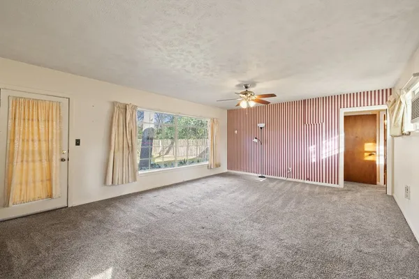 a view of a livingroom with a ceiling fan and window