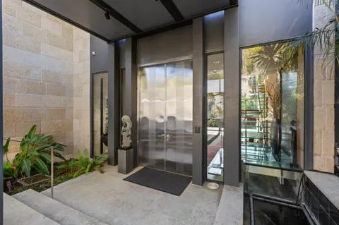 a view of a house with a large windows and plants