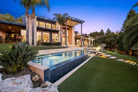 a view of a house with a swimming pool and a chairs