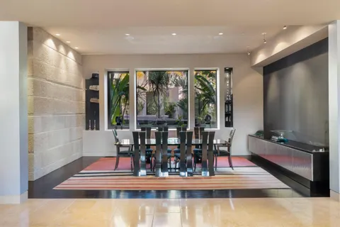 a room with furniture a large window and a potted plant