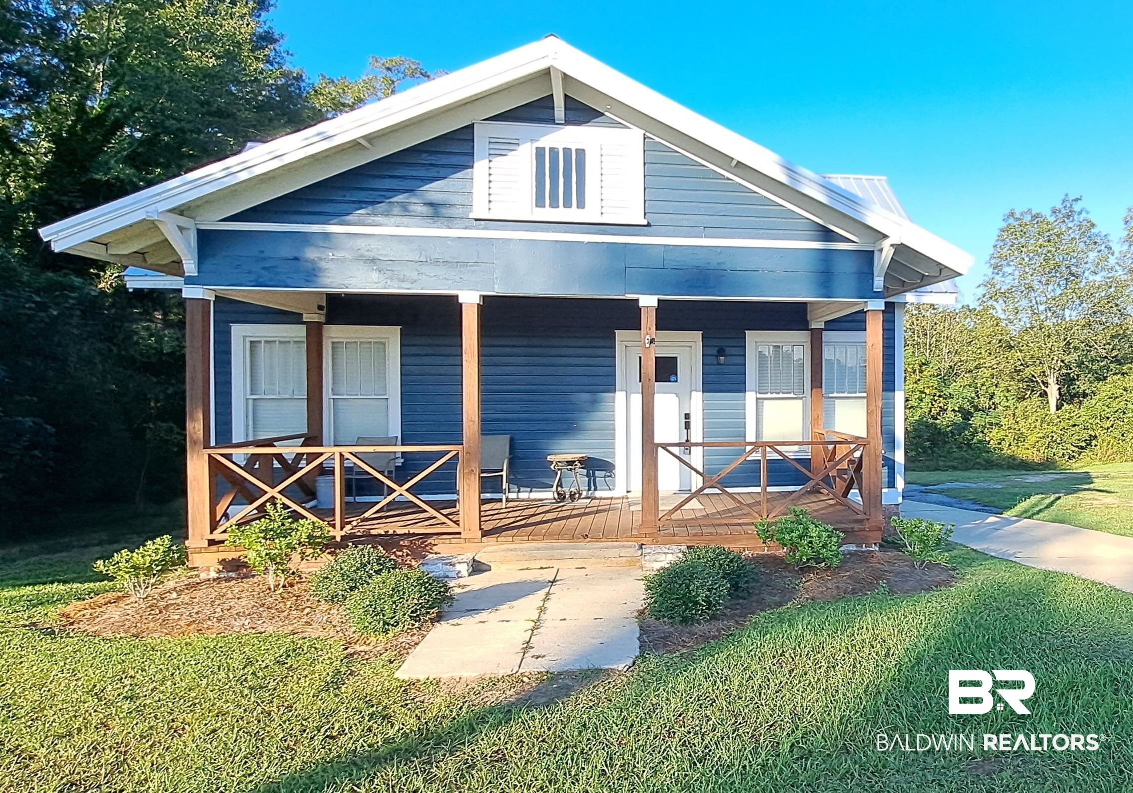 110 South Main Street Evergreen, AL 36401 - Photo 1 of 27 Craftsman-style home featuring blue siding, a white metal roof, and a covered front porch with exposed wood beams