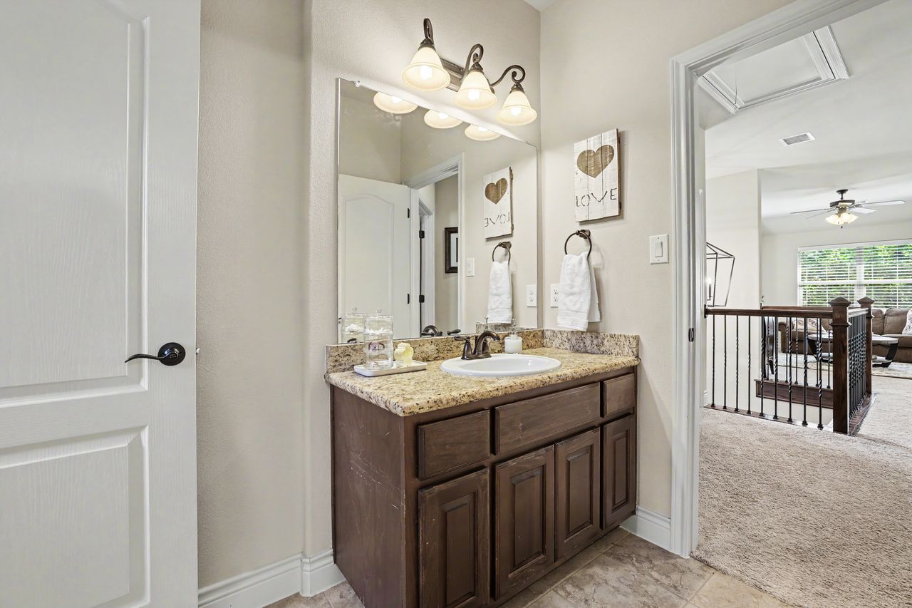 809 Prairie Dunes Drive Georgetown, TX 78628 - Photo 33 of 40 Granite counters and a warm wood vanity create a welcoming powder room with convenient access to the upper level living space.