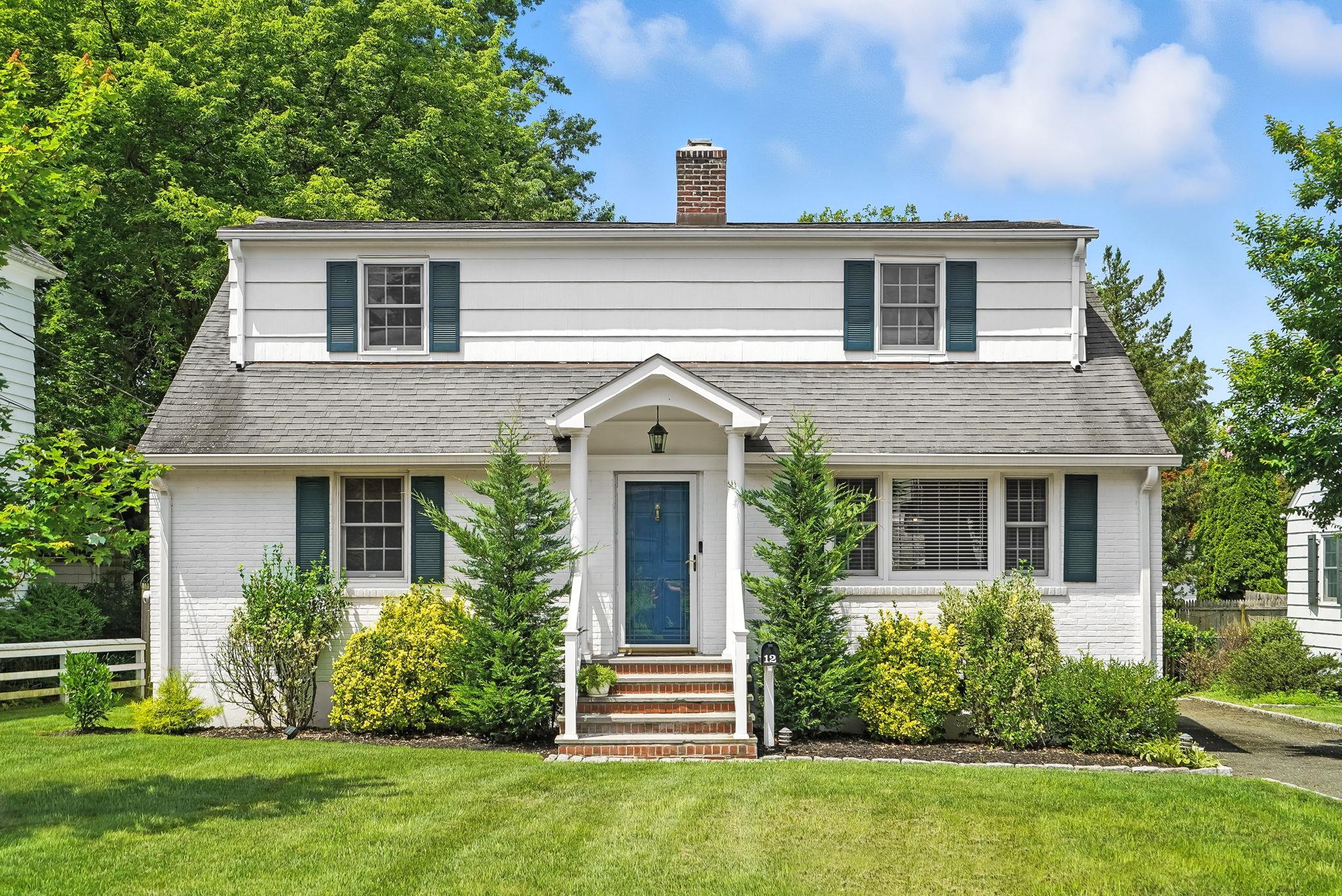 a front view of a house with a garden and plants