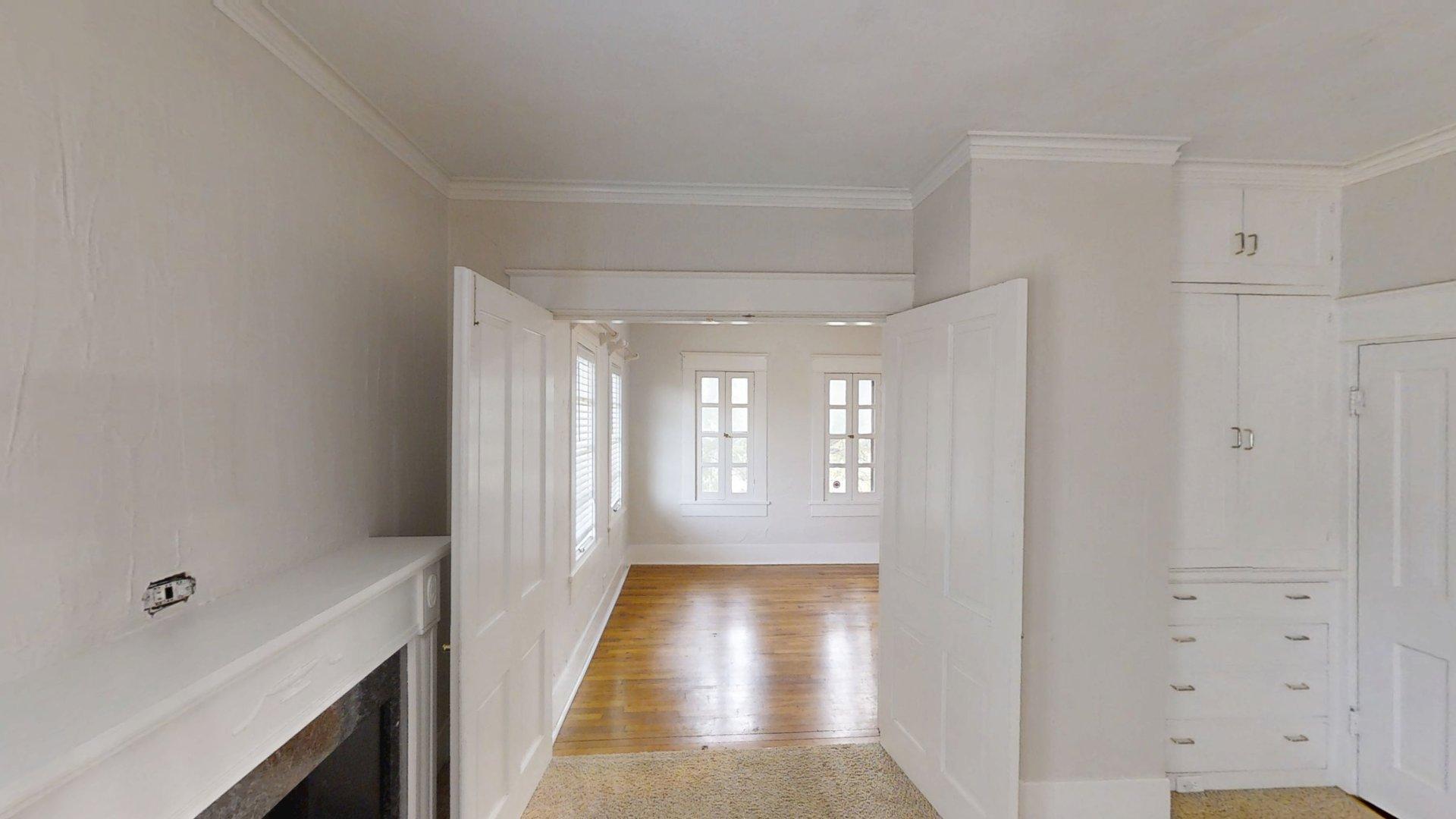 219 F Street Southwest Ardmore, OK 73401 - Photo 24 of 58 Wood-finish flooring, white paneled doors, built-in cabinetry, crown molding, and a fireplace mantel
