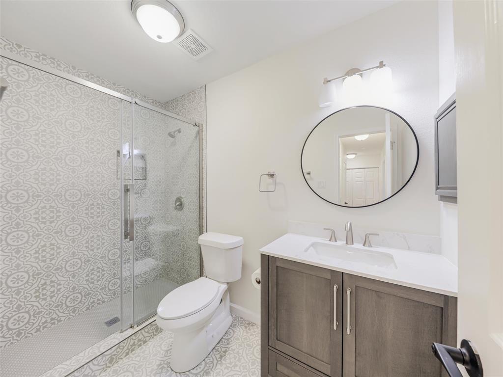 2327 North Ridge Road McKinney, TX 75072 - Photo 12 of 26 Glass-enclosed shower with patterned tile surround, built-in shower bench, and hexagonal tile flooring