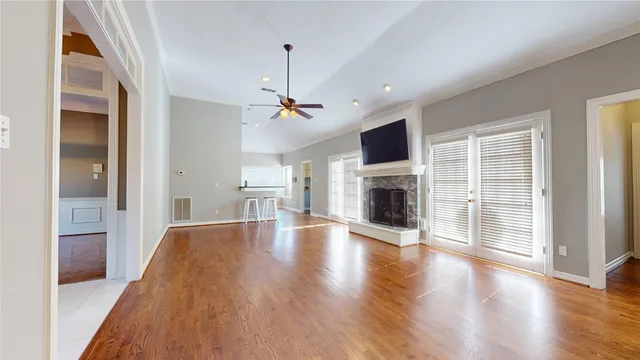 a view of empty room with wooden floor and fireplace