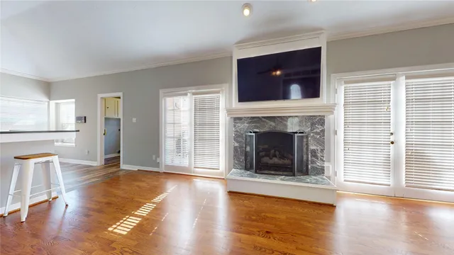 a living room with a fireplace a flat screen tv and a large window