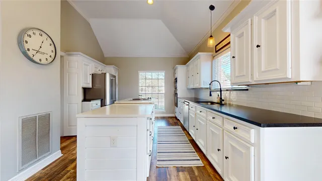 a large white kitchen with a large window and stainless steel appliances