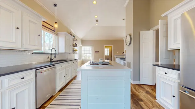 a kitchen with white cabinets and sink