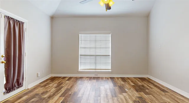 an empty room with window and wooden floor