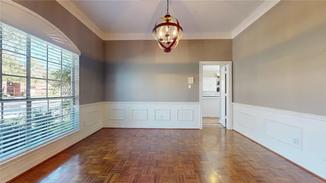 a view of an empty room with wooden floor and windows