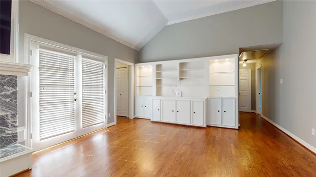 an empty room with wooden floor and cabinet
