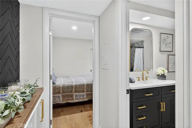 a en suite bathroom with a granite countertop sink and mirror